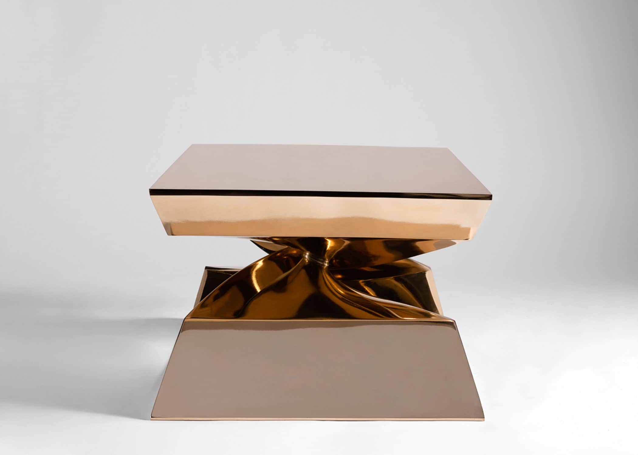 This image shows the large X shaped bronze Coffee Table designed by Carol Egan in a side profile.  The CE24 Cast silicon bronze X shaped coffee table has a mirror polished finish.  30"w x 24"d x 18"h.   The table is shown here against a grey background.