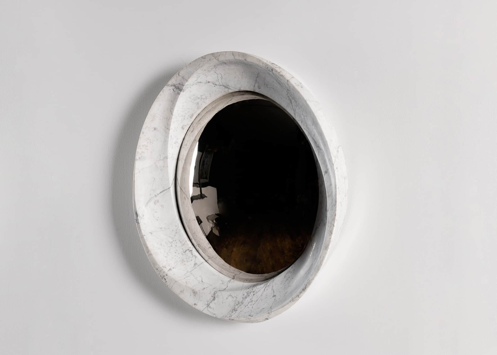 This image shows the CE10 mirror carved Carrara marble, convex polished stainless steel inset designed by Carol Egan.  The diameter is 39.5" (100cm) view front elevation.