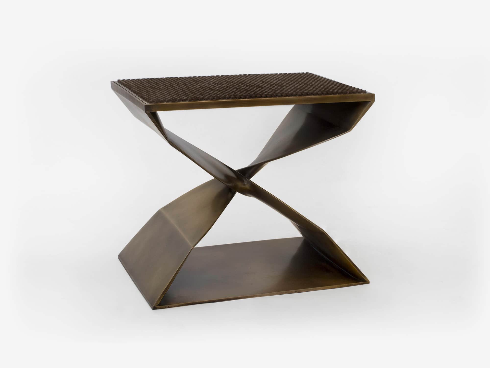Fabricated with a lost wax casting process this image shows an isometric view of the CE06 X Stool with a custom woven bronze and leather seat top.  Designed for a special commission by Carol Egan the dimensions of the stool are 18"h x 22"w x 15"d (46 x 56 x 38cm).