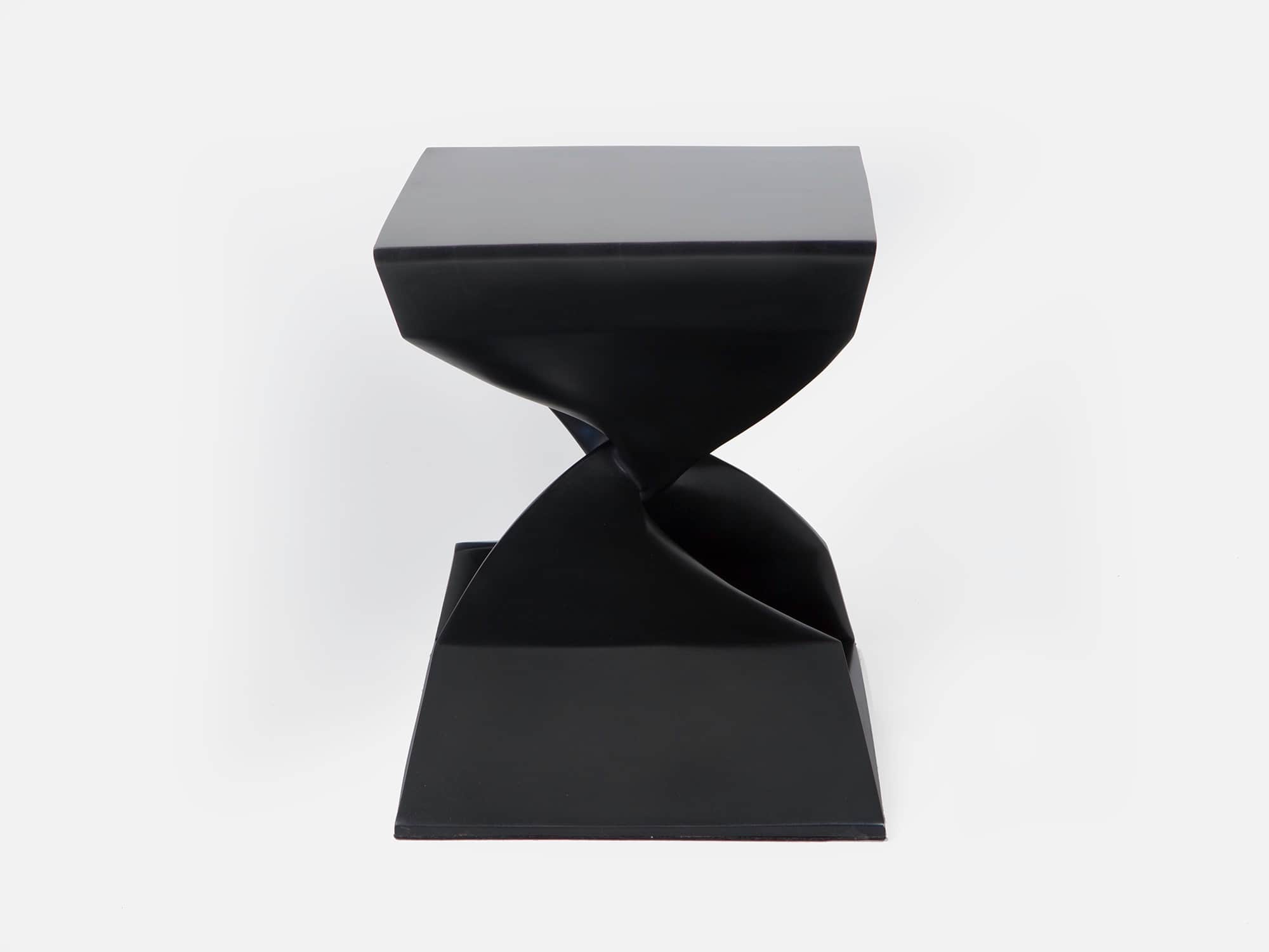 Designed by Carol Egan this image displays a side view of the CE06 X Stool in a blackened bronze finish. The piece is made using a lost was casting and the dimensions are 18"h x 22"w x 15"d (46 x 56 x 38cm).
