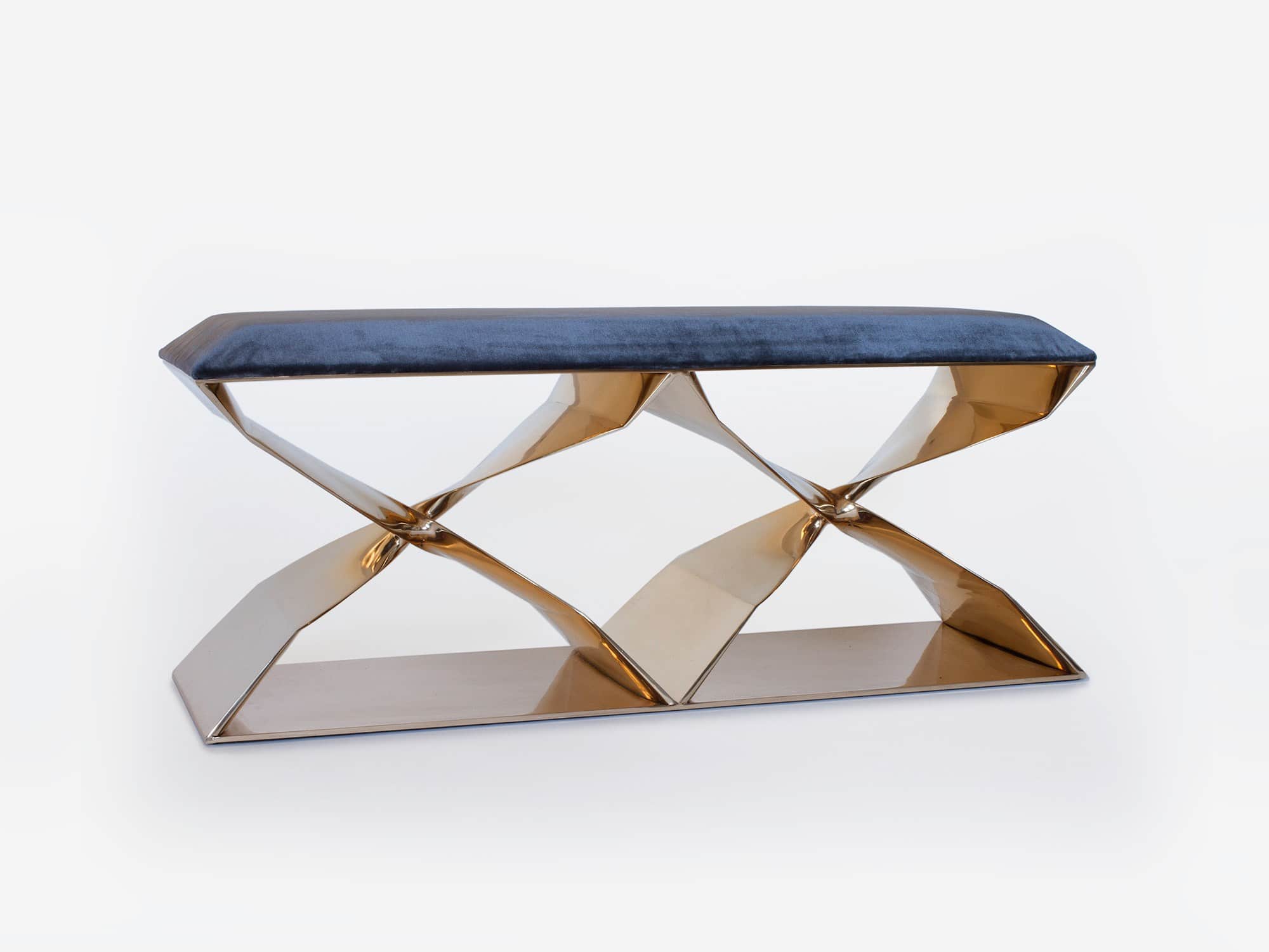 Employing the lost wax casting technique, this image shows the CE07 XX Bench in a polished silicon Bronze mirror finish with a blue velvet upholstered seat top.  Designed by Carol Egan the dimensions of the bench are 18"h X 45"w X 15"d (46 X 115 X 38cm).