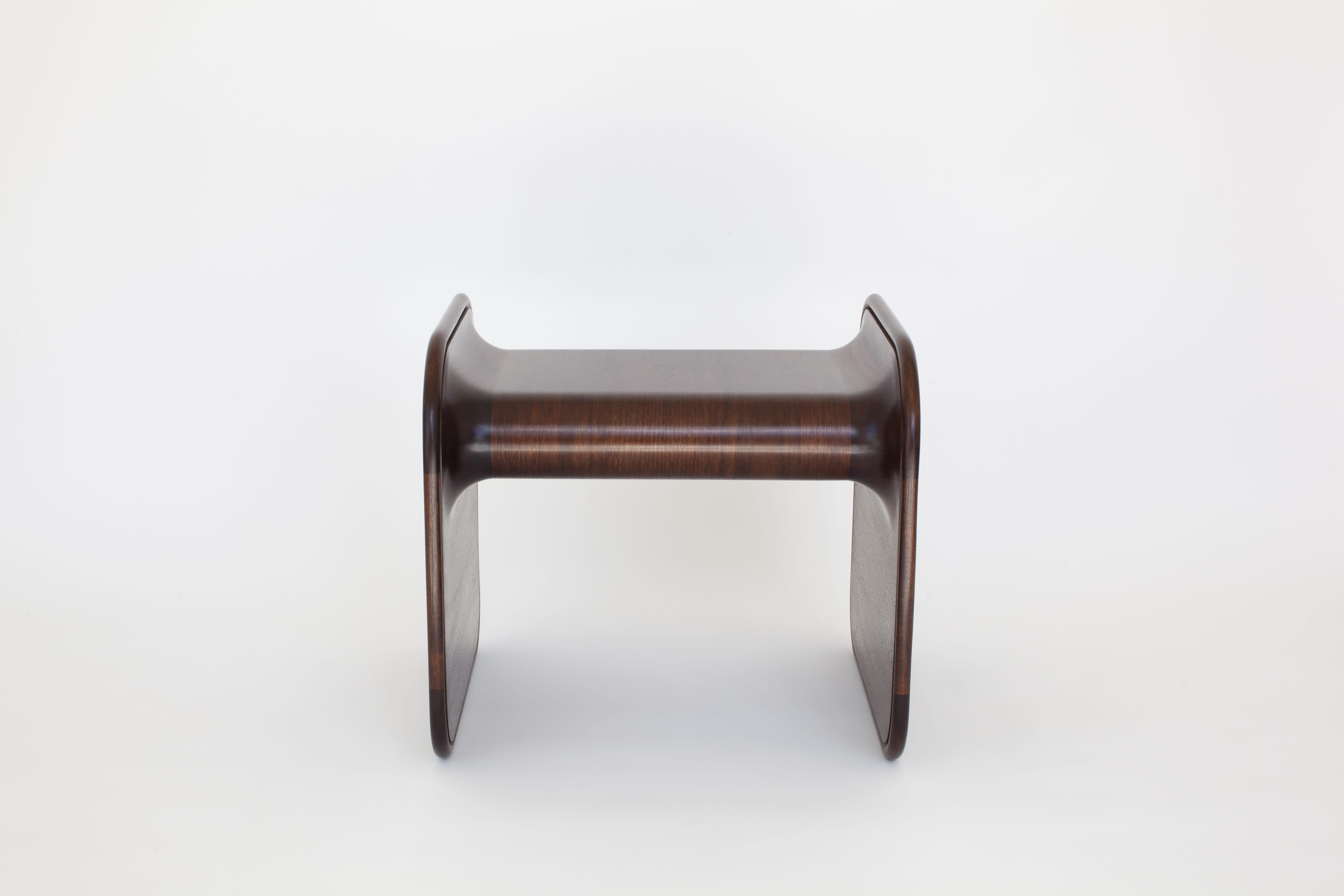 Designed by Carol Egan, the Surf Bench in American Walnut measures 19.5”h x 20”w x 19”d