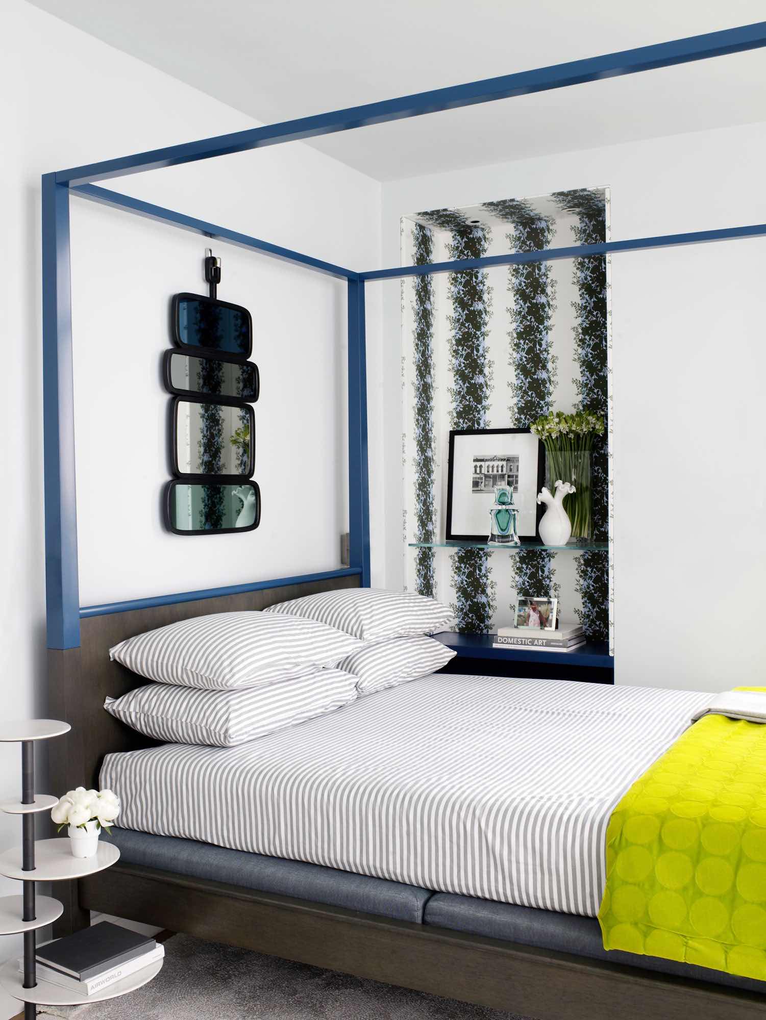 An image of the master bedroom designed by Carol Egan with a Zanzibar bed by Christian Liaigre in “Vice Versa" Laurier 4 by Pierre Frey and a "Interstellar" side table by Isabelle Azema.  The room is accessorized with a custom throw by Nigel Atkinson and Country mirror by Hubert Le Gall.  Niche in Brunschwig & Fils Rayure Fleurie Toile fabric by Madeleine Castaing.