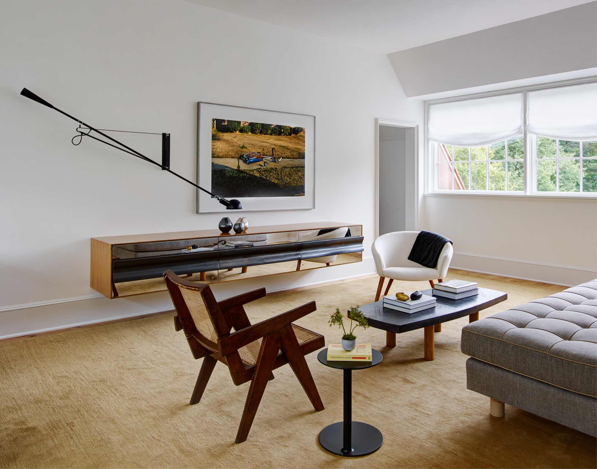 Designed by Carol Egan, the upstairs sitting room consist of an Easy Armchair by Pierre Jeanneret, coffee table by Roger Capron, Ciranda side table by Ricardo Fasanello and Pot chair by Nana Ditzel.  The "Untitled, Bike on Sidewalk" large photograph by William Eggleston hangs above a custom cabinet by Studio Carol Egan with a Model 265 wall light by Paolo Rizzatto.