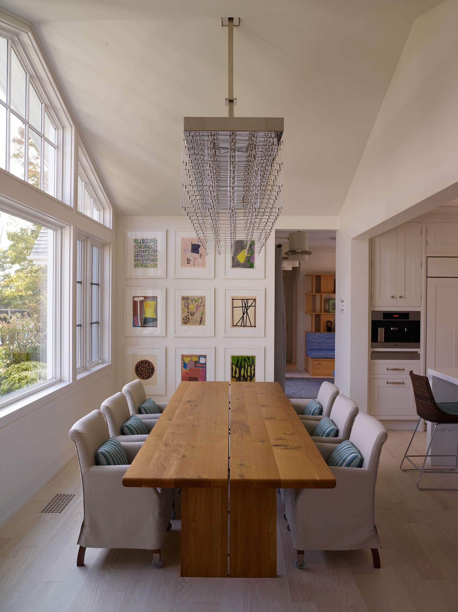 Designed by Carol Egan, this image shows the breakfast room table and chairs with Artwork by Jorge Fick.  The Oak dining table is flanked by linen slipcovered Piet boon dining chairs.