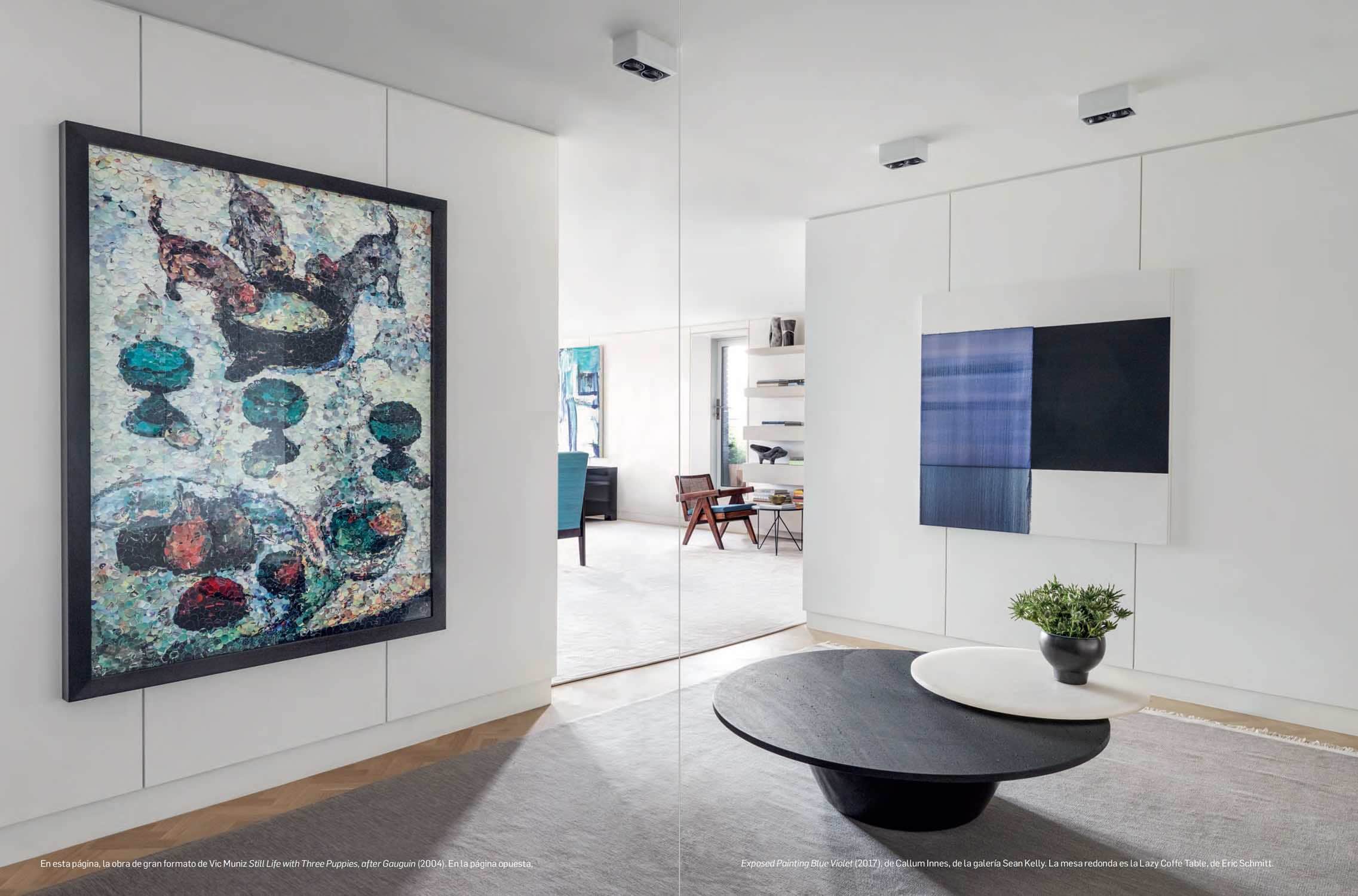 Photograph of a library designed by Carol Egan Interiors with Exposed Painting Delft Blue/Violet by Callum Innes, Artwork by Vik Muniz and Lazy Moon coffee table by Eric Schmitt.